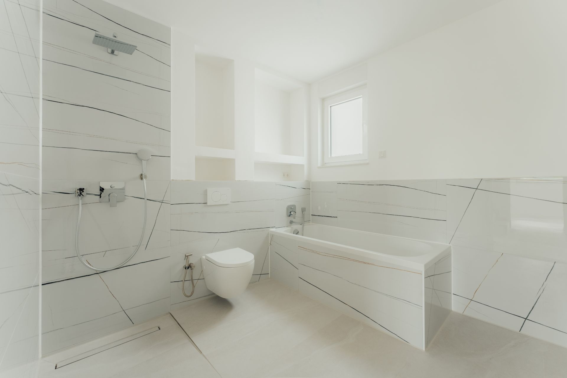 Modernes, helles Badezimmer mit Dusche, Badewanne, WC und Fenster.