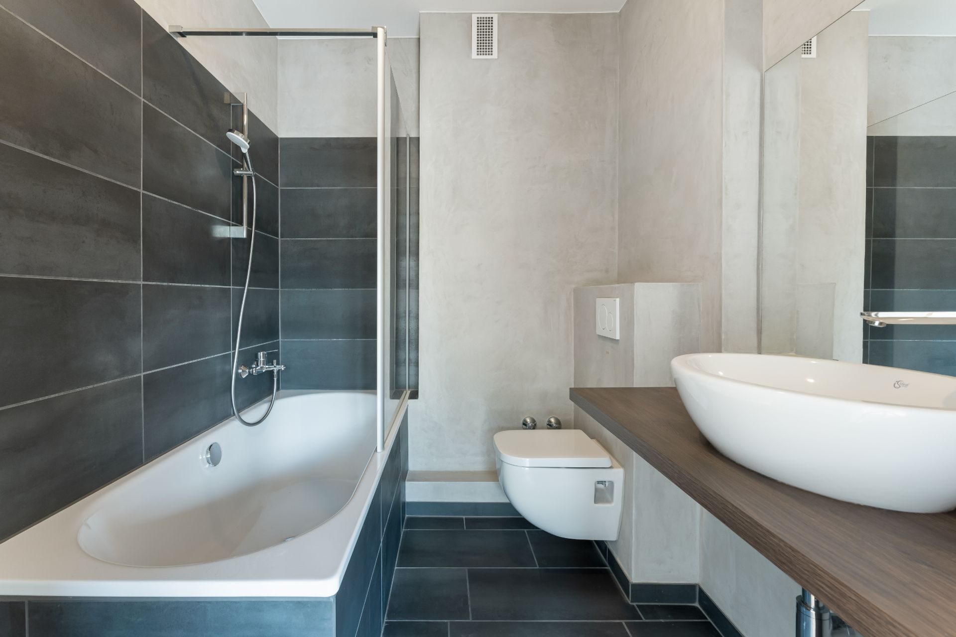 Modernes Badezimmer mit Badewanne, Wandtoilette und Waschbecken auf Holztisch.
