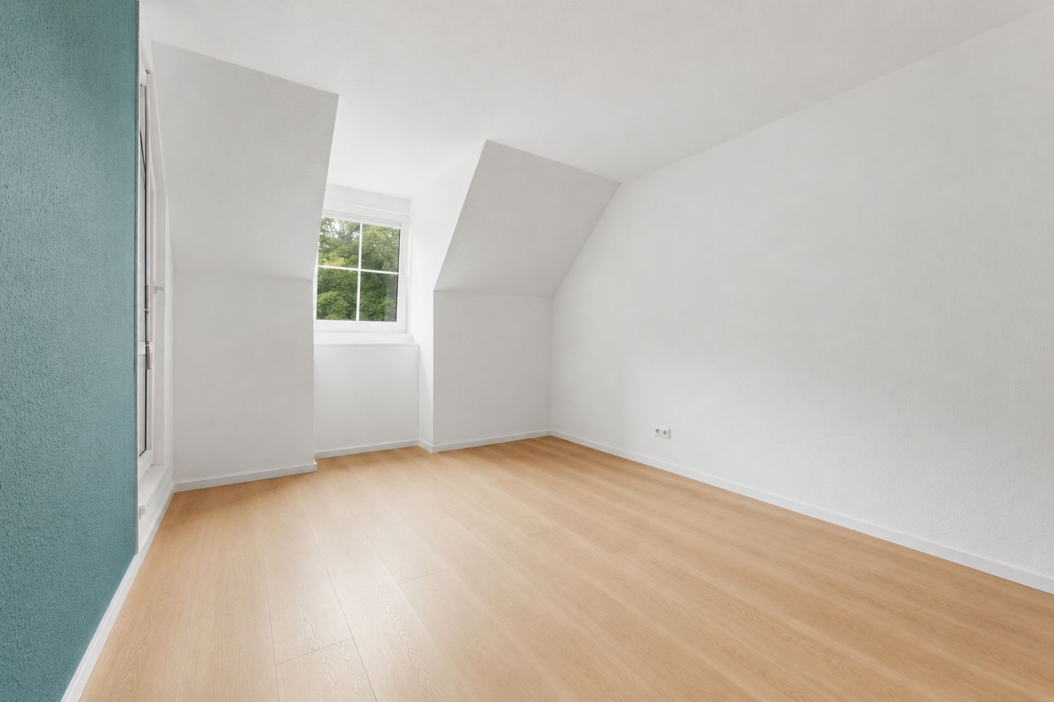Heller leerer Raum mit Holzfußboden, weiß gestrichenen Wänden und einem Fenster.