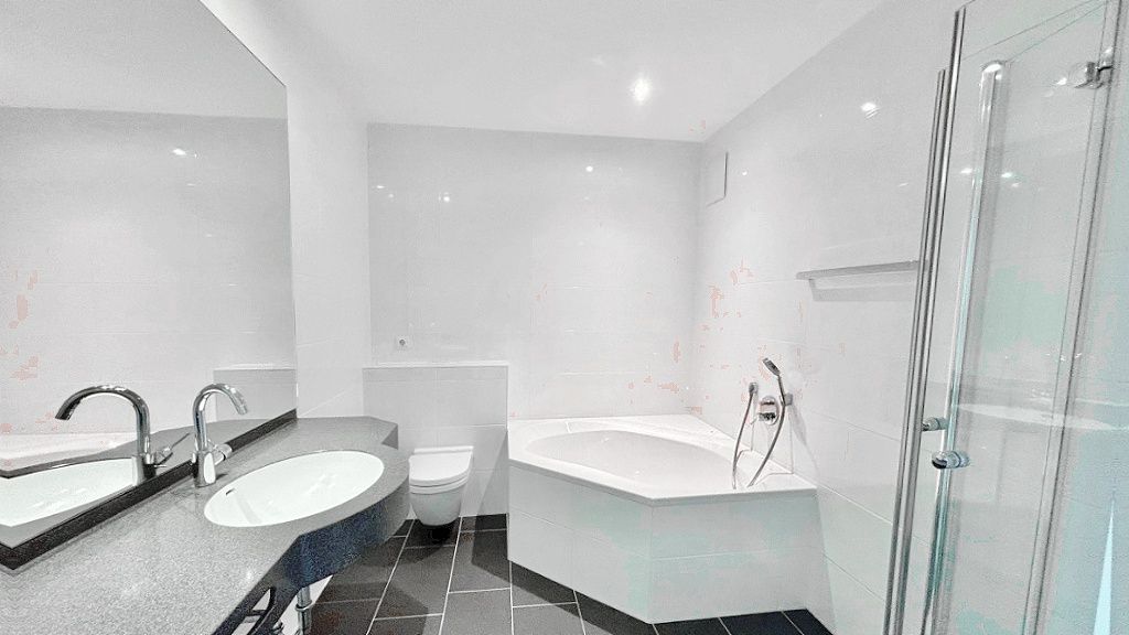 Modernes Badezimmer mit Eckbadewanne, Dusche, Doppelwaschbecken und WC.