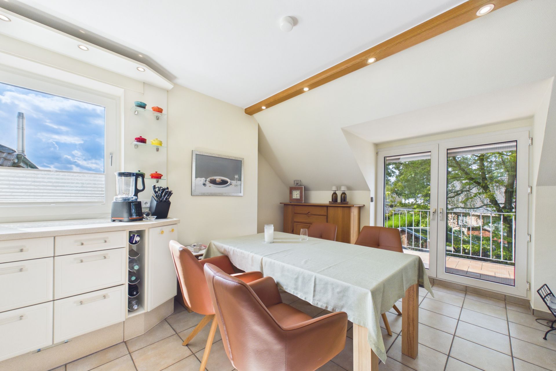 Heller Essbereich mit vier Stühlen, Esstisch, Fenster und Zugang zum Balkon.