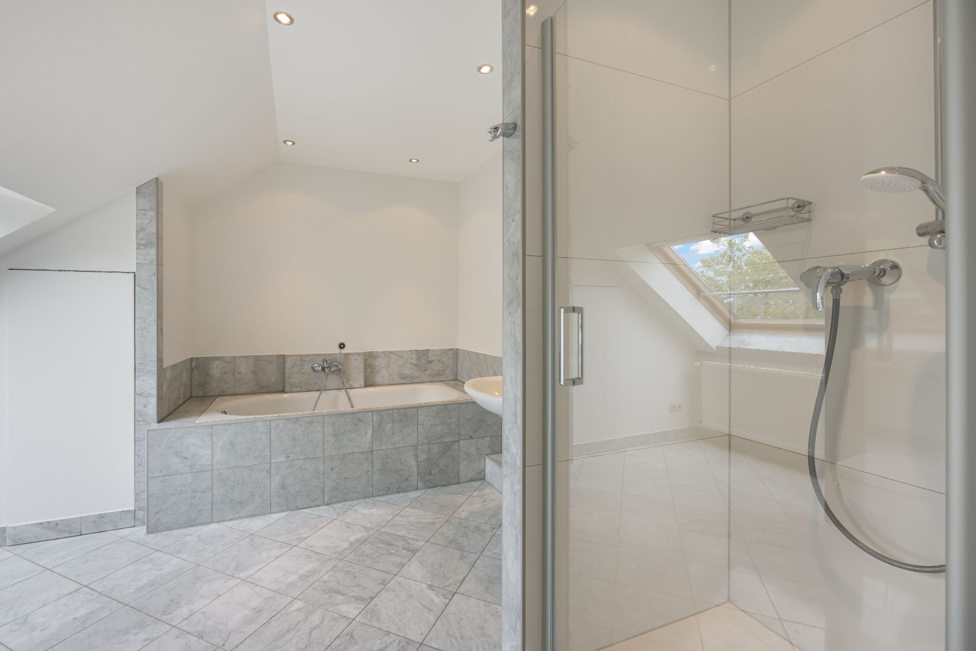 Modernes Badezimmer mit Badewanne, Dusche und großem Fenster.