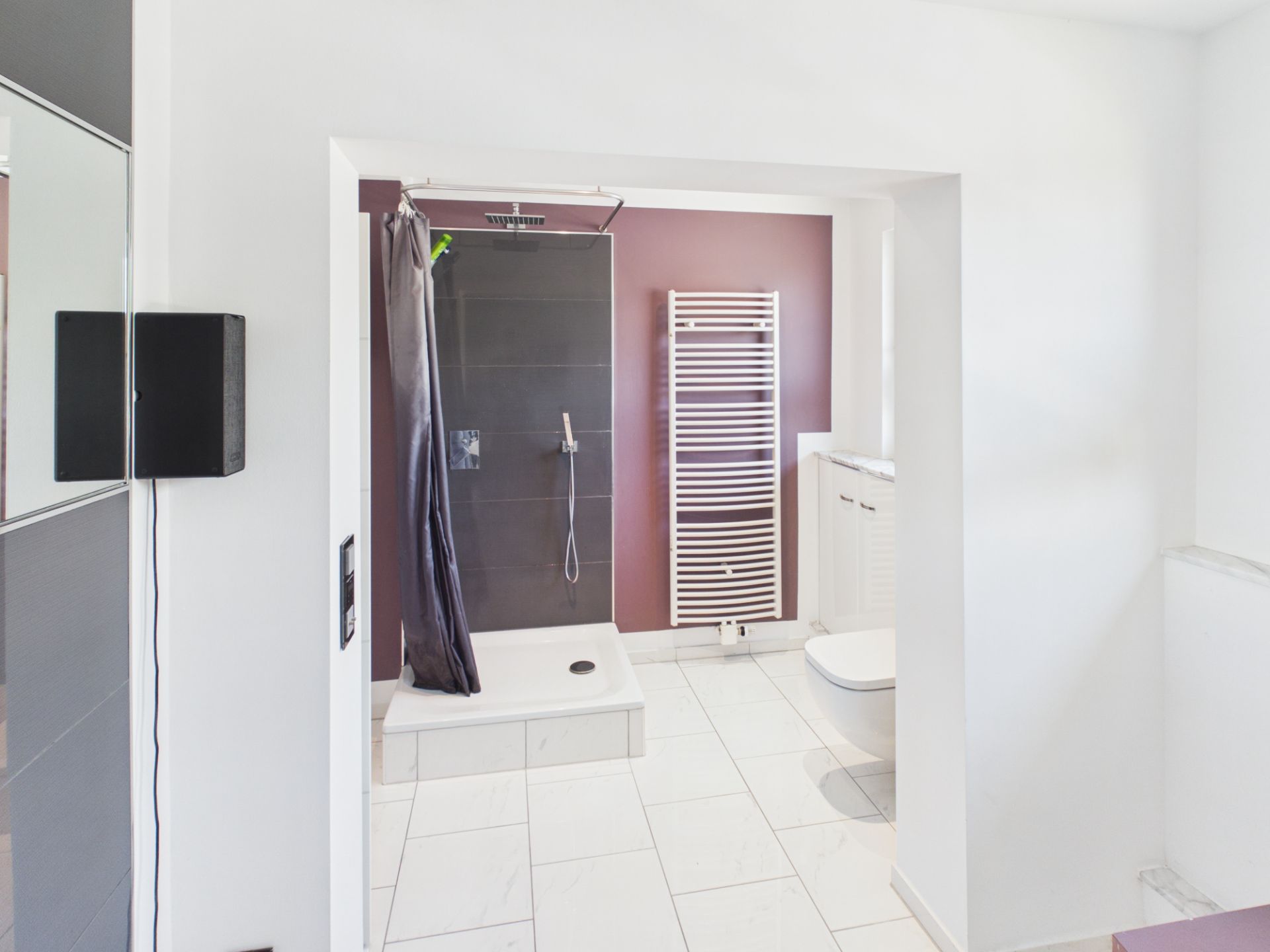Modernes Badezimmer mit offener Dusche, Handtuchheizkörper und weißen Fliesen.