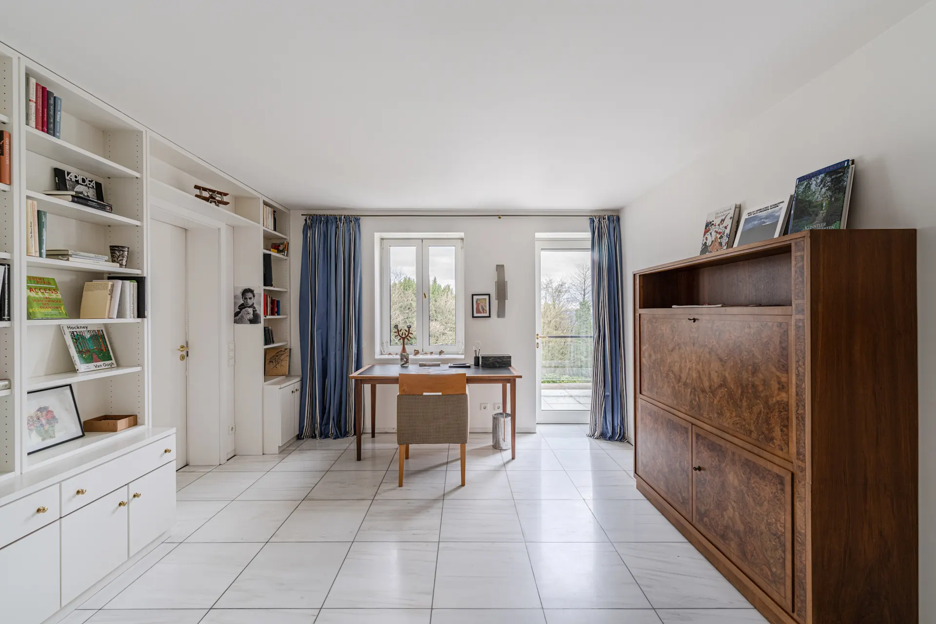 Helles Arbeitszimmer mit Schreibtisch, Regal, Holzschrank und weißen Fliesenboden.
