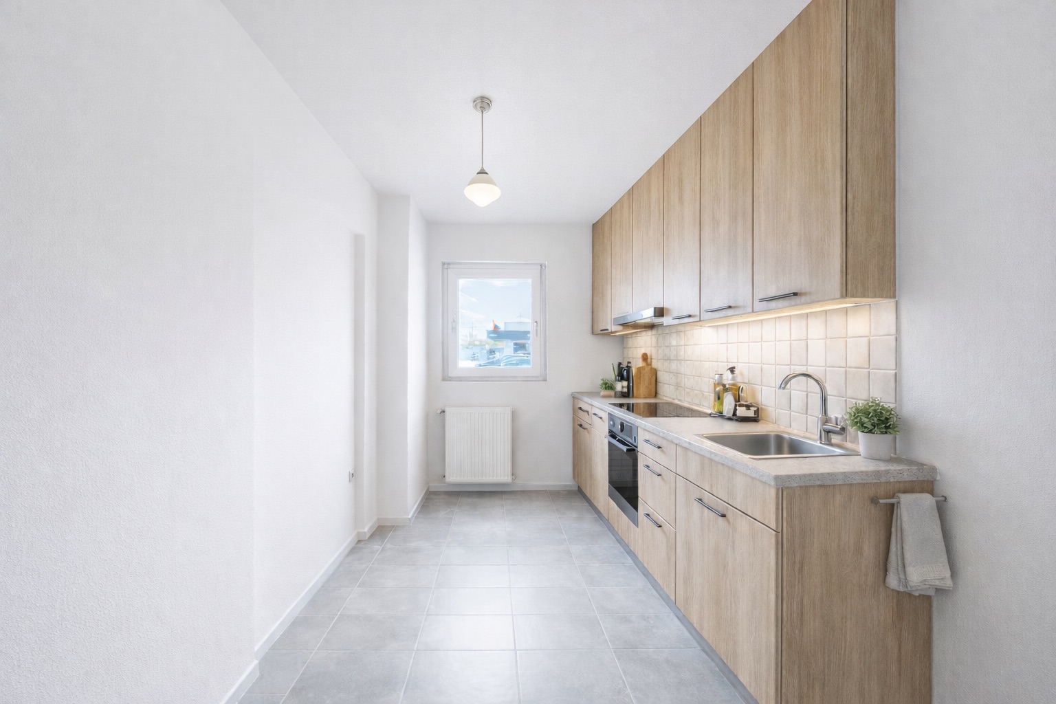 Helle, moderne Küche mit Holzschränken, Fenster und gefliestem Boden.