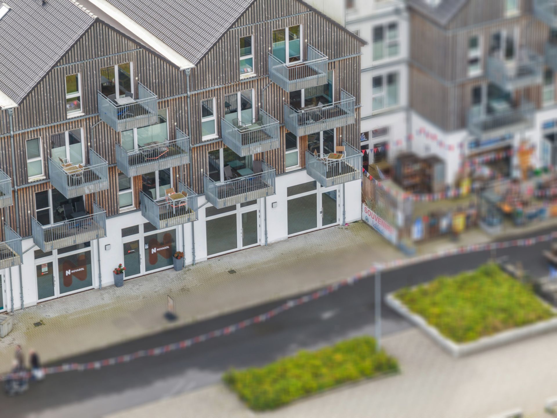 Modernes Wohngebäude mit Holzelementen und mehreren Balkonen an der Straßenseite.