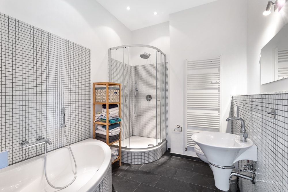 Modernes Badezimmer mit Badewanne, Dusche, Waschbecken, Regal und Handtuchheizkörper.