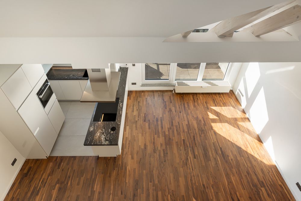 Moderne Küche und heller Wohnbereich mit Holzfußboden, Blick von oben.