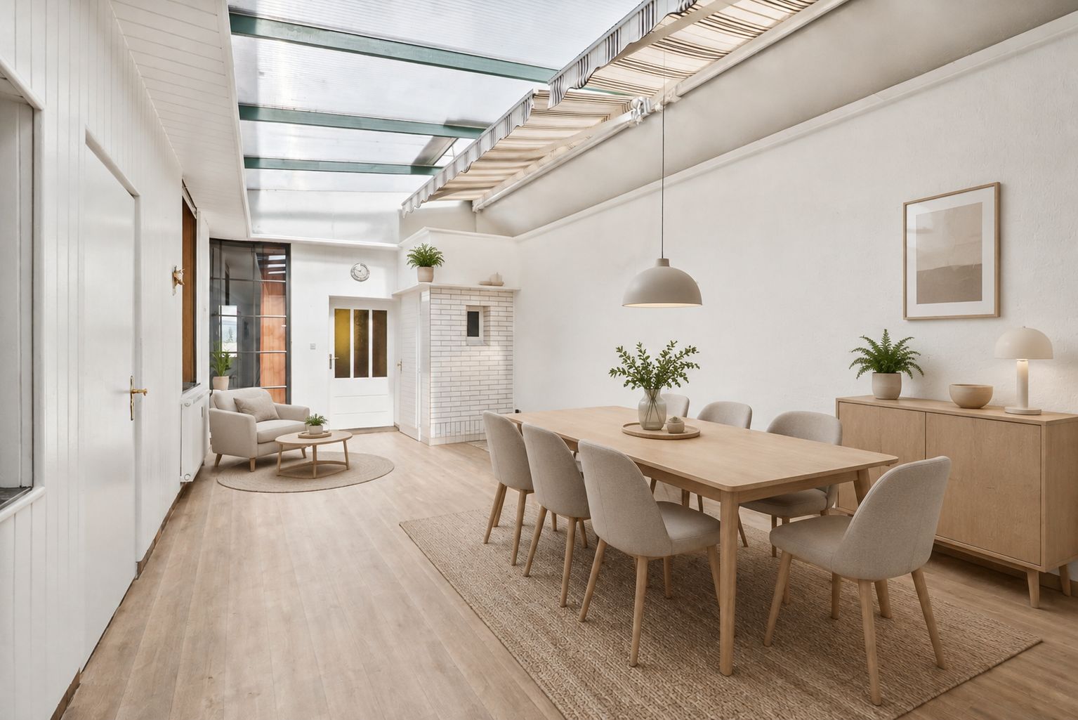 Heller Essbereich mit großem Holztisch, acht Stühlen und Sideboard in modernem Raum mit Glasdach.