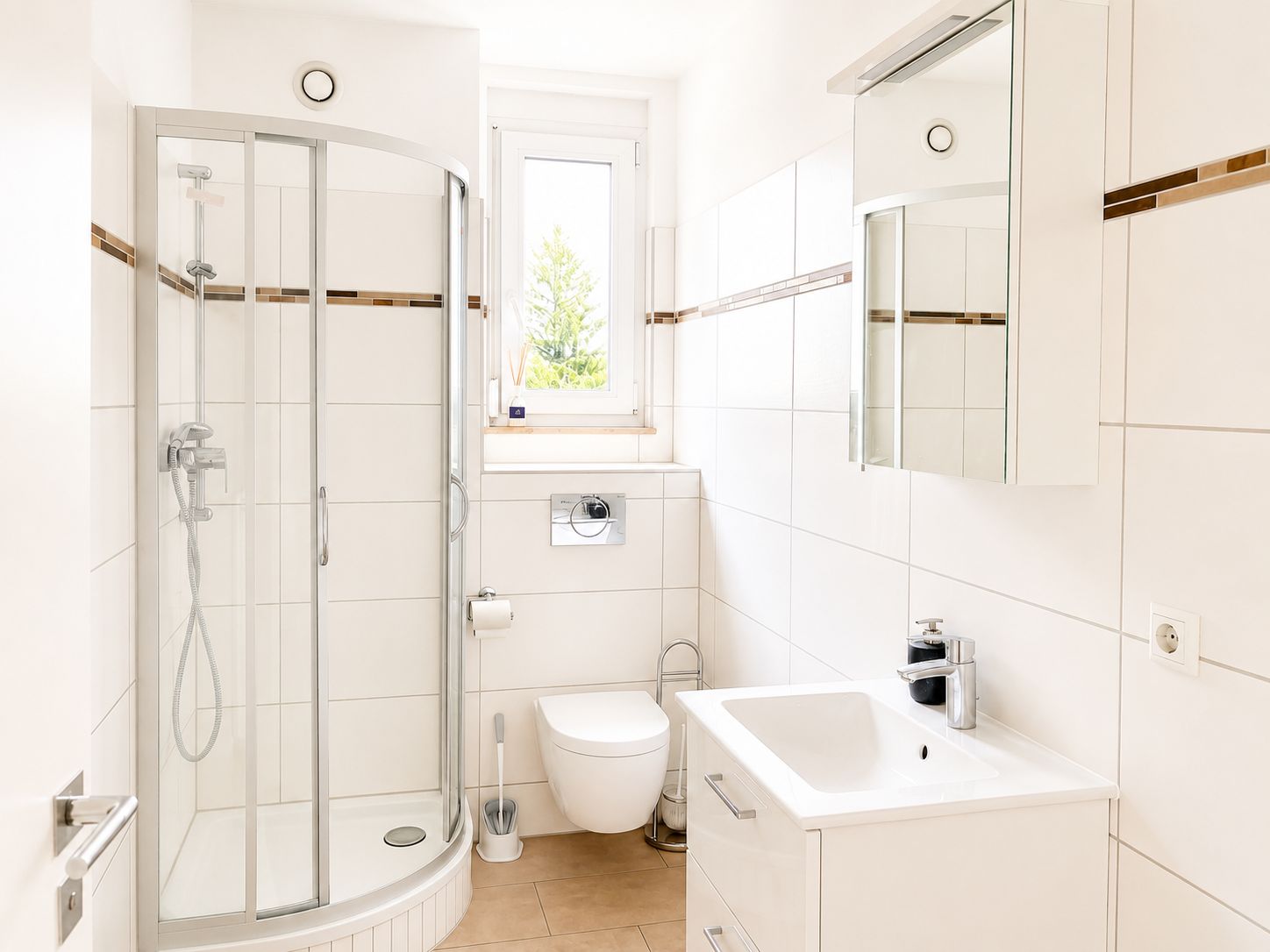 Helles Badezimmer mit Dusche, Toilette, Waschbecken und Spiegelschrank.