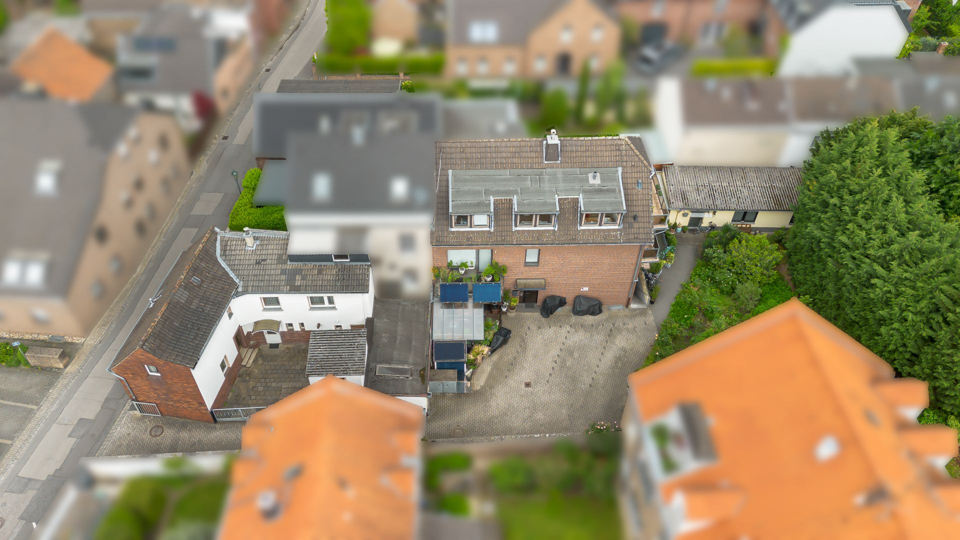 Luftaufnahme eines Wohnhauses mit Hof und mehreren angrenzenden Gebäuden.