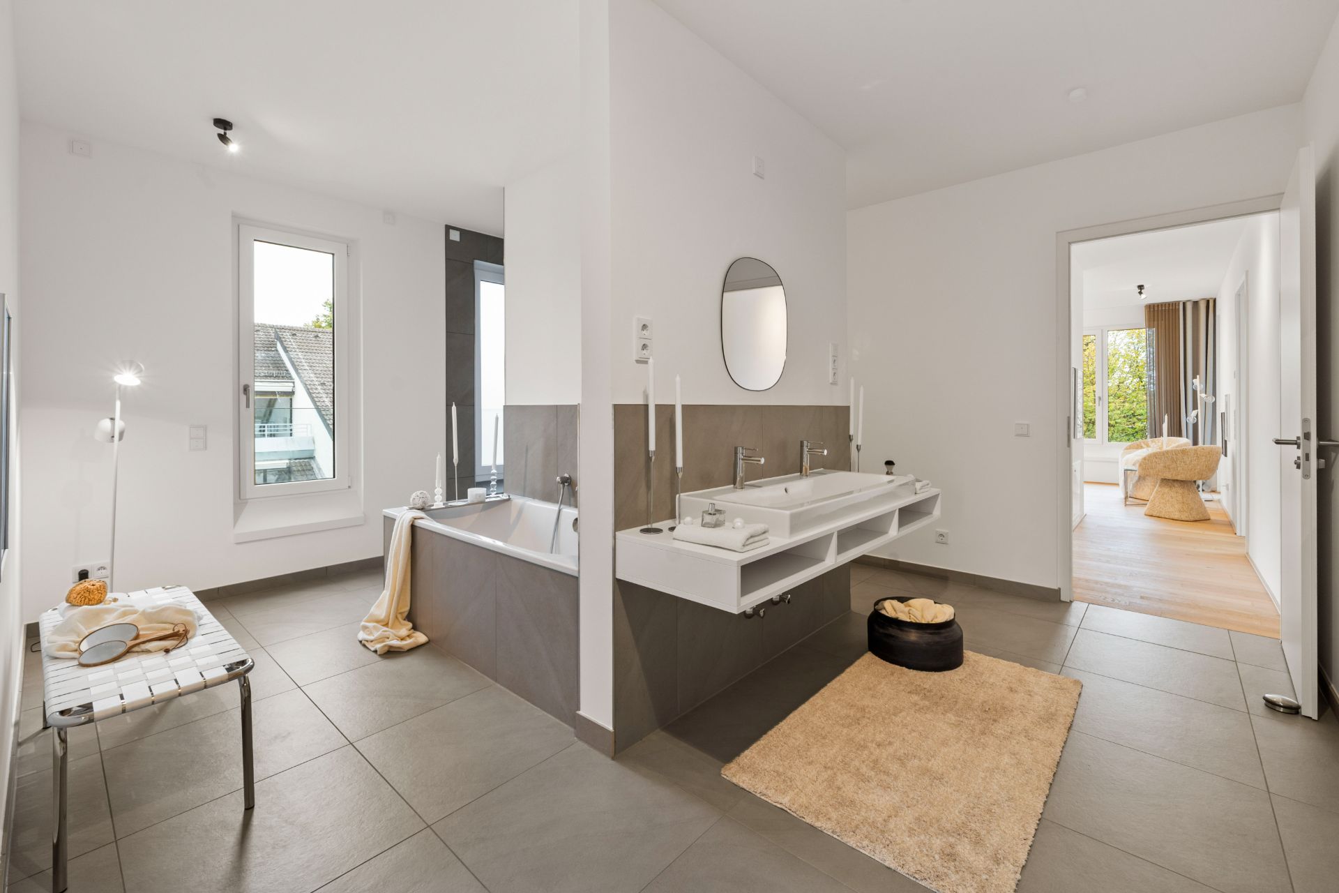 Modernes Badezimmer mit Badewanne, Doppelwaschbecken und hellen Fliesen.