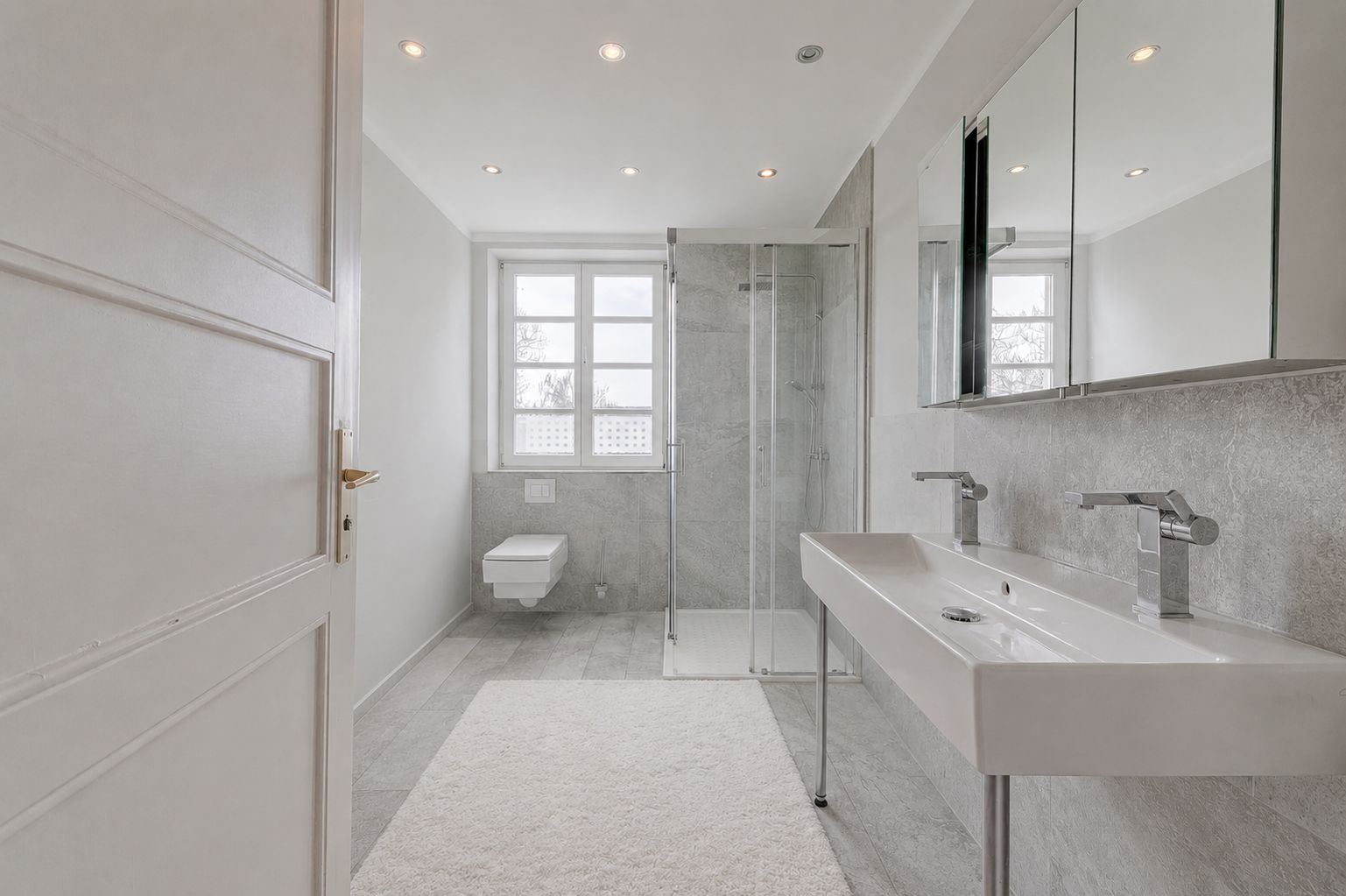 Modernes Badezimmer mit Dusche, Doppelwaschbecken, Spiegel und Fenster.