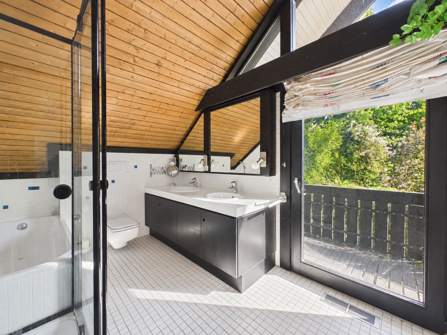 Modernes Badezimmer mit Glasdusche, Doppelwaschbecken und großem Fenster zur Terrasse.