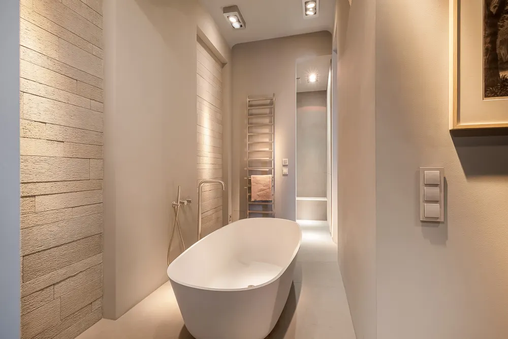 Modernes Badezimmer mit freistehender Badewanne und Handtuchheizkörper an der Wand.