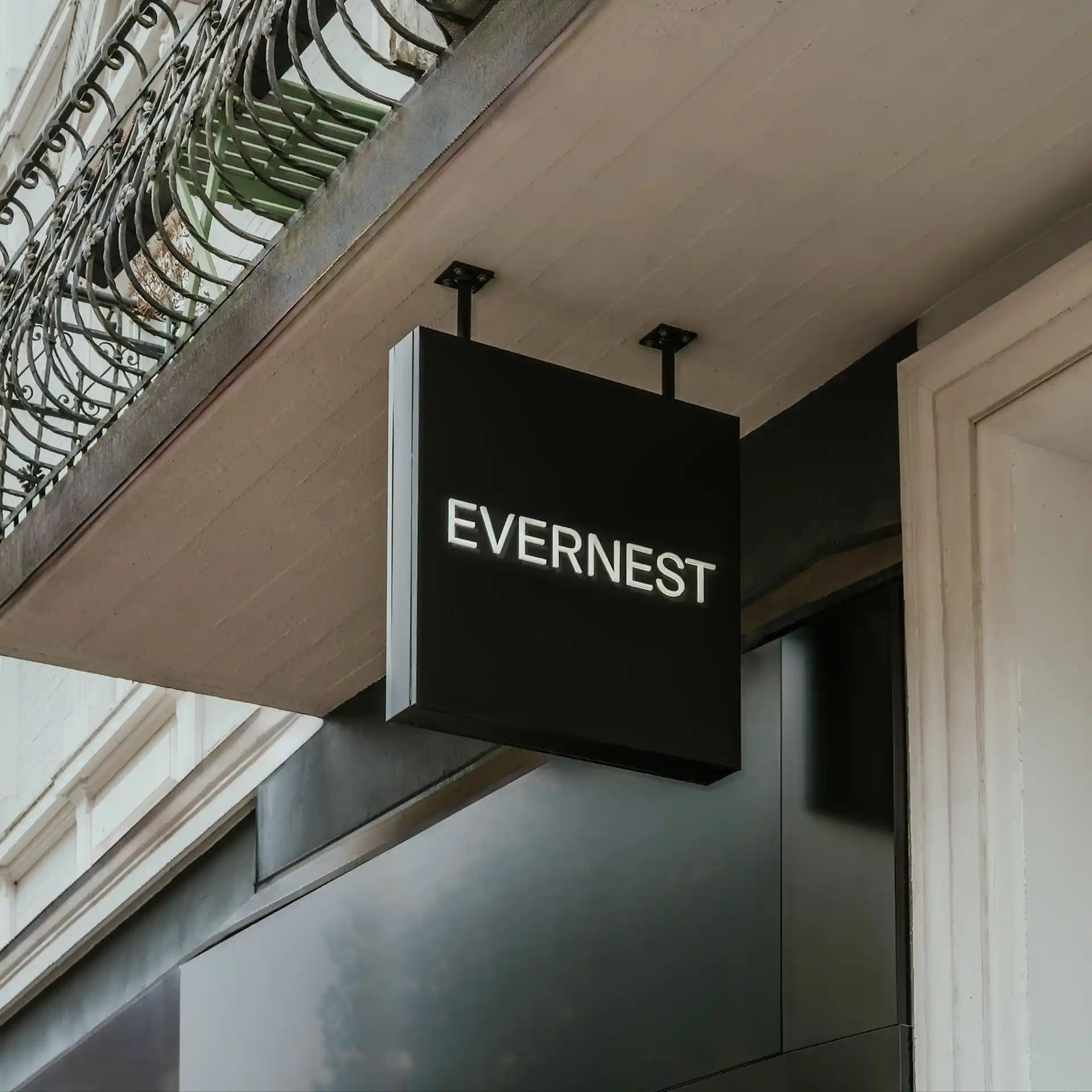 Schwarzes Schild mit weißer Aufschrift 'EVERNEST' an einer Hausfassade.