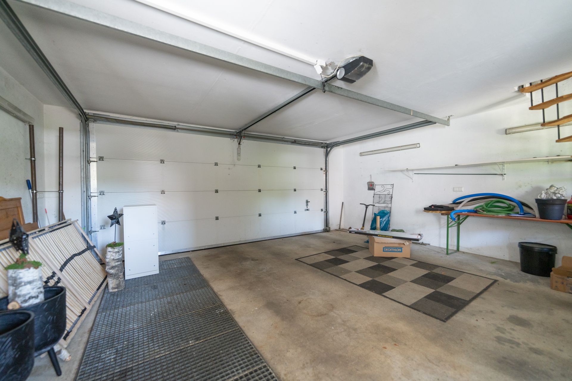 Innenansicht einer leeren Garage mit Regalen und Stauraum an den Wänden.