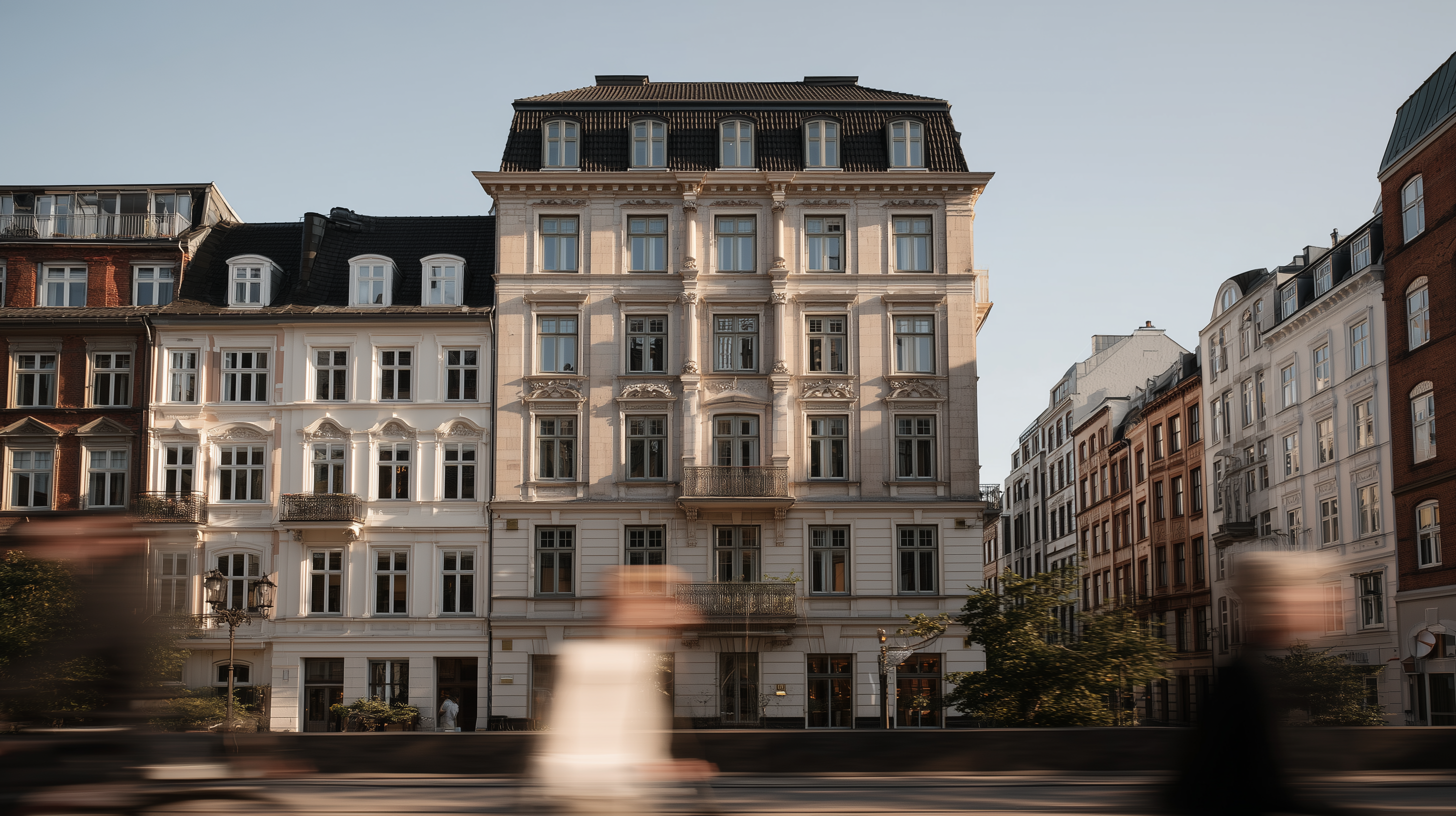 Mehrstöckiges Wohngebäude mit klassischer Fassade, umgeben von weiteren Stadthäusern.