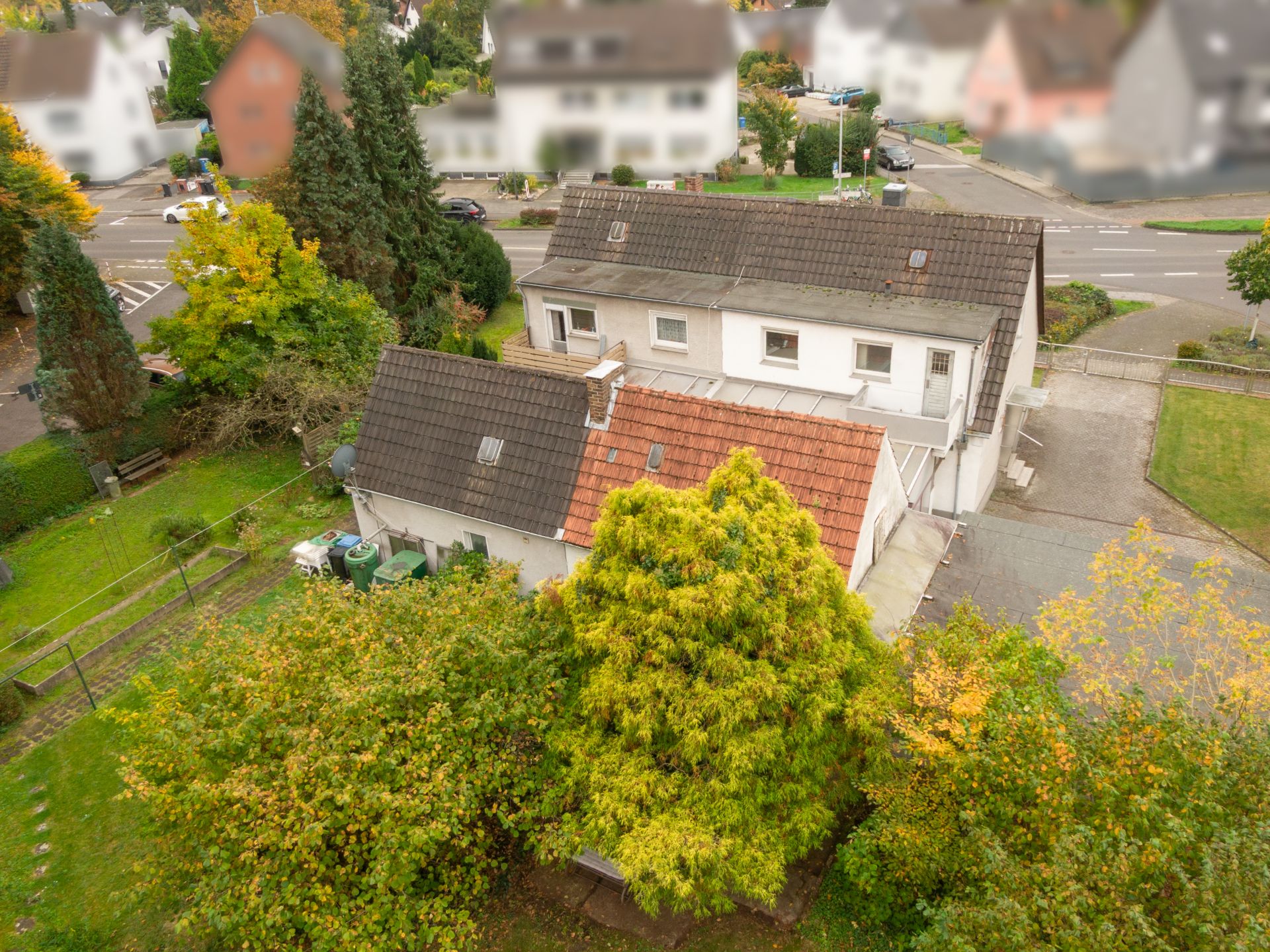 Zweistöckiges Wohnhaus mit Garten und Bäumen, aufgenommen aus der Vogelperspektive.