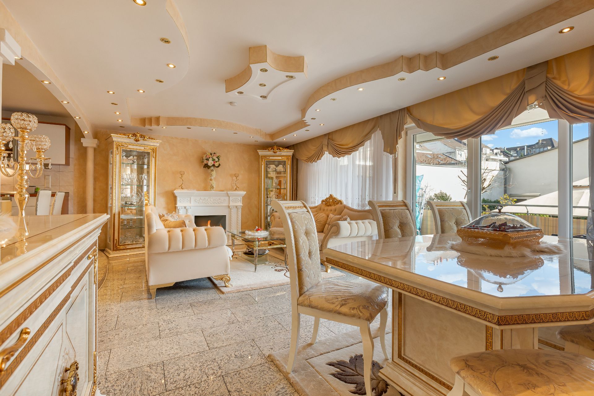 Helles, elegant eingerichtetes Wohnzimmer mit großen Fenstern und luxuriösem Essbereich.