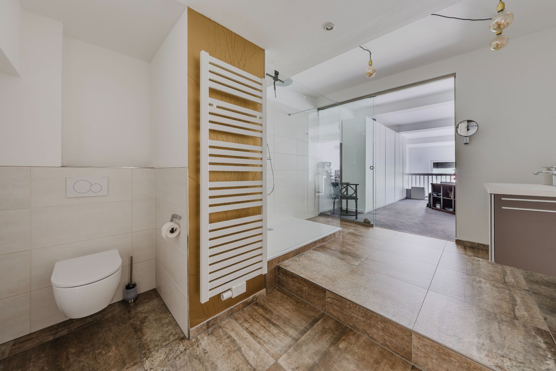 Modernes Badezimmer mit Dusche, Wandtoilette, Waschbecken und Handtuchheizkörper.