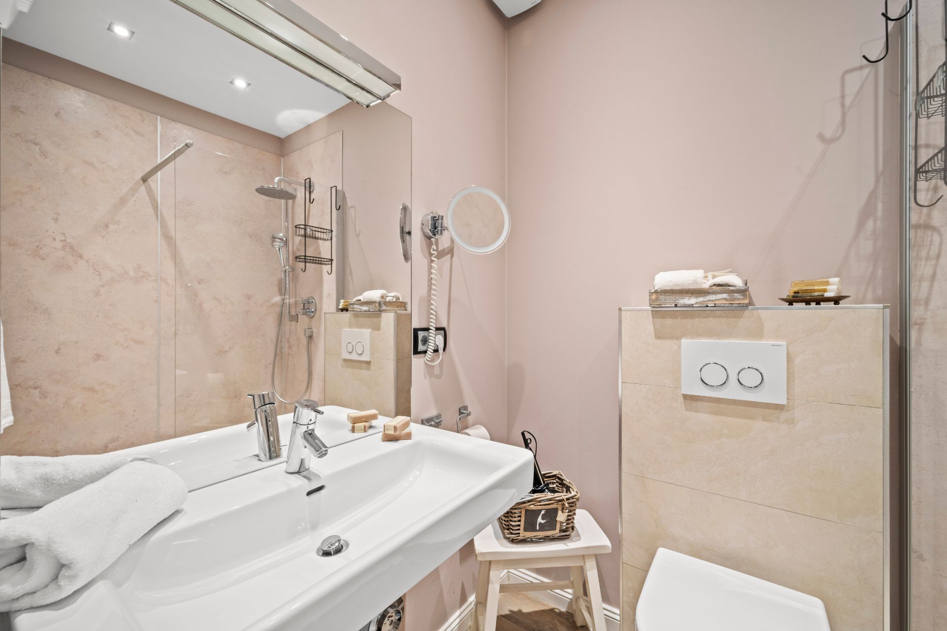 Modernes Badezimmer mit Waschbecken, Dusche, WC und Spiegel an der Wand.