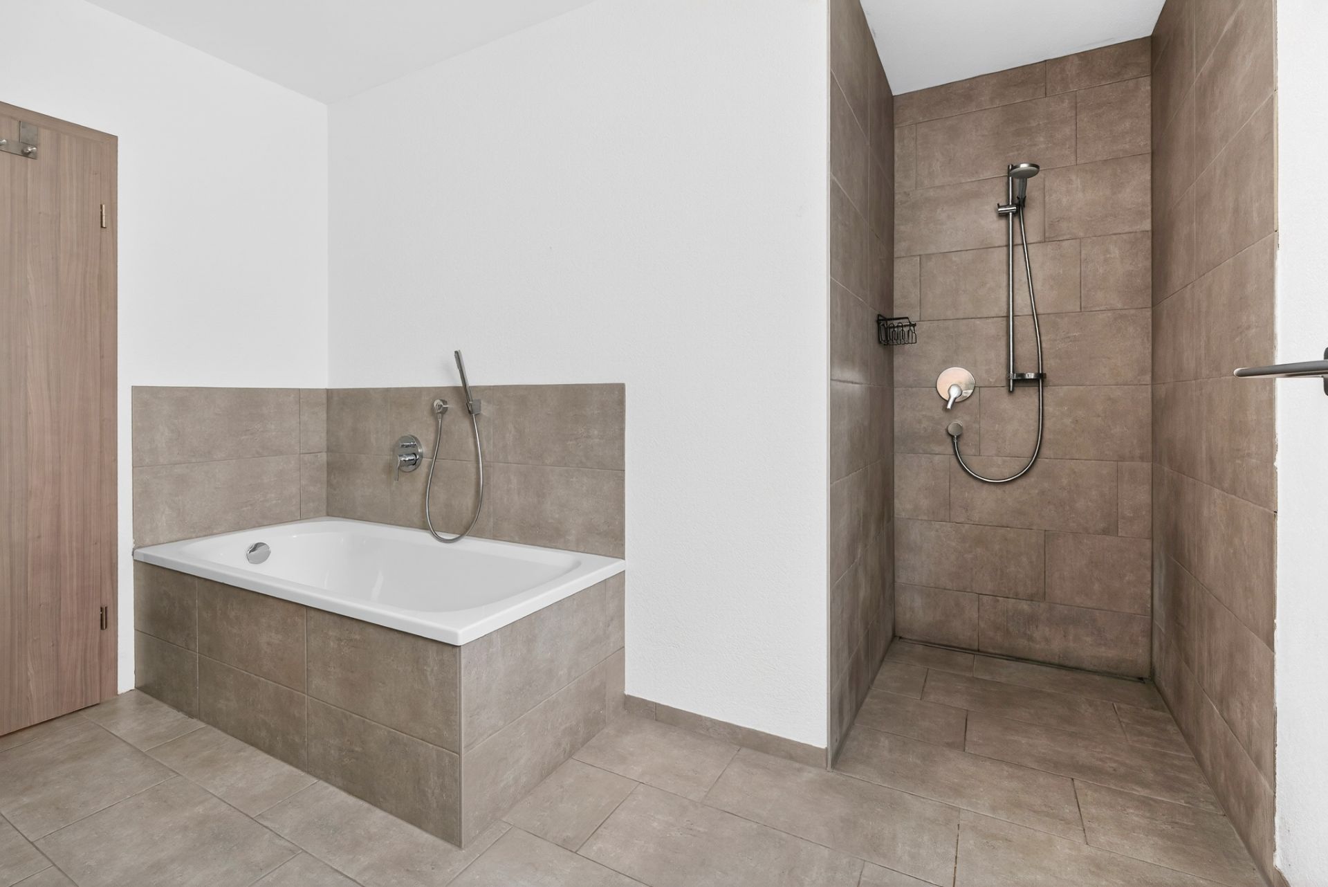 Modernes Badezimmer mit Badewanne und ebenerdiger Dusche, braune Fliesen an Boden und Wänden.