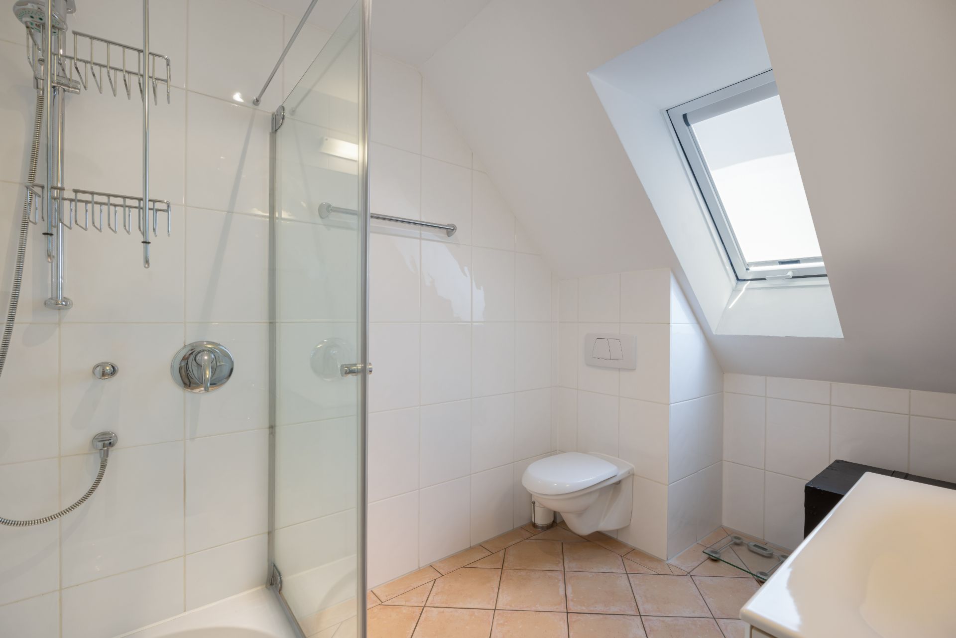 Modernes Badezimmer mit Dusche, WC, Badewanne und Dachfenster.