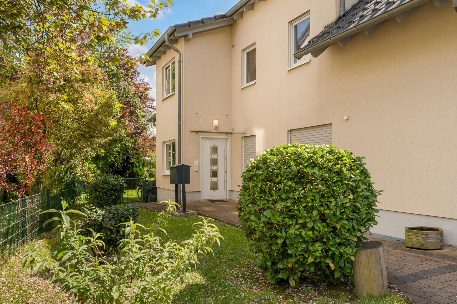 Zweistöckiges Wohnhaus mit hellem Putz, Vorgarten und Briefkasten am Eingang.