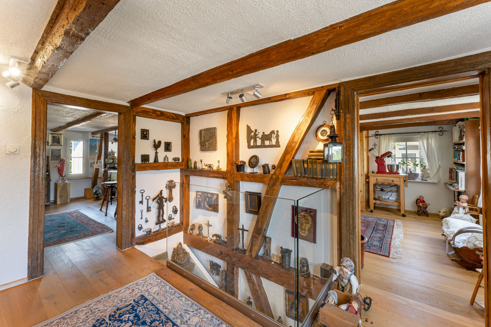Flur in einem Wohnhaus mit Holzbalken, Dekorationen und Zugang zu mehreren Zimmern.