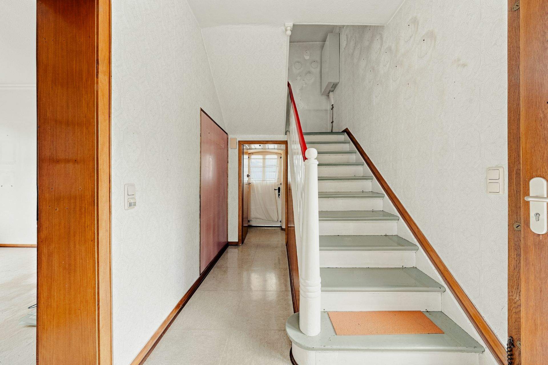 Heller Flur mit Treppe nach oben und Türen zu weiteren Zimmern.