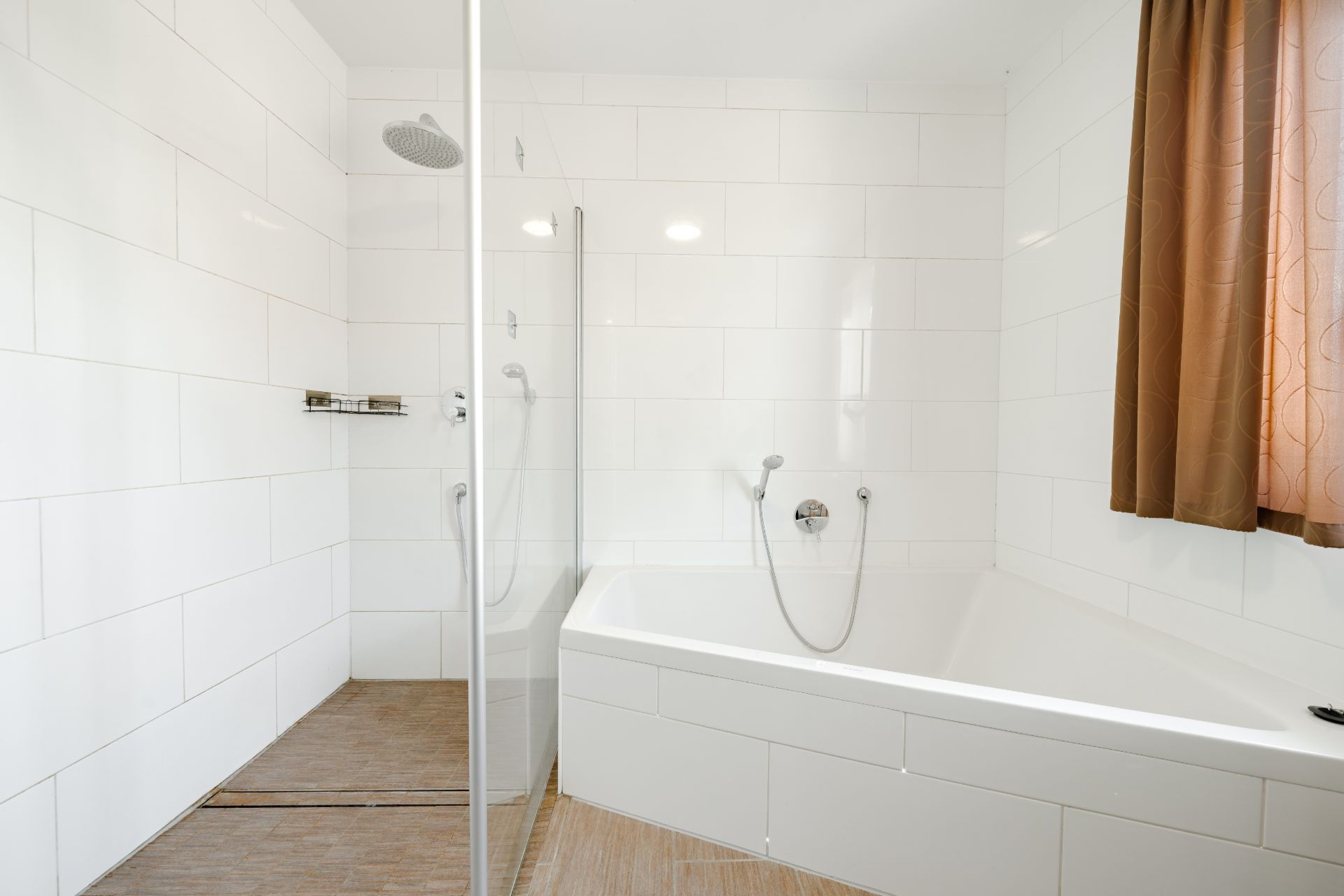 Modernes Bad mit begehbarer Dusche, Badewanne und braunem Vorhang am Fenster.