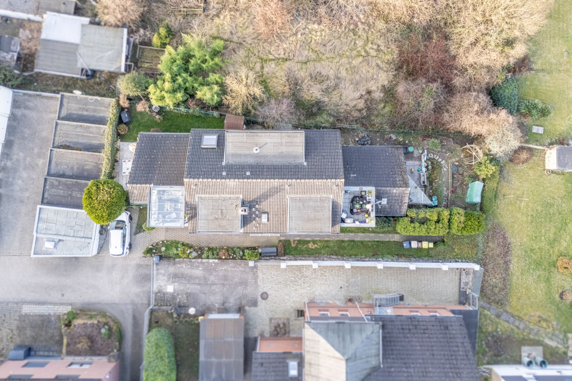 Luftaufnahme eines Wohnhauses mit Garten und umgebenden Grundstücken.
