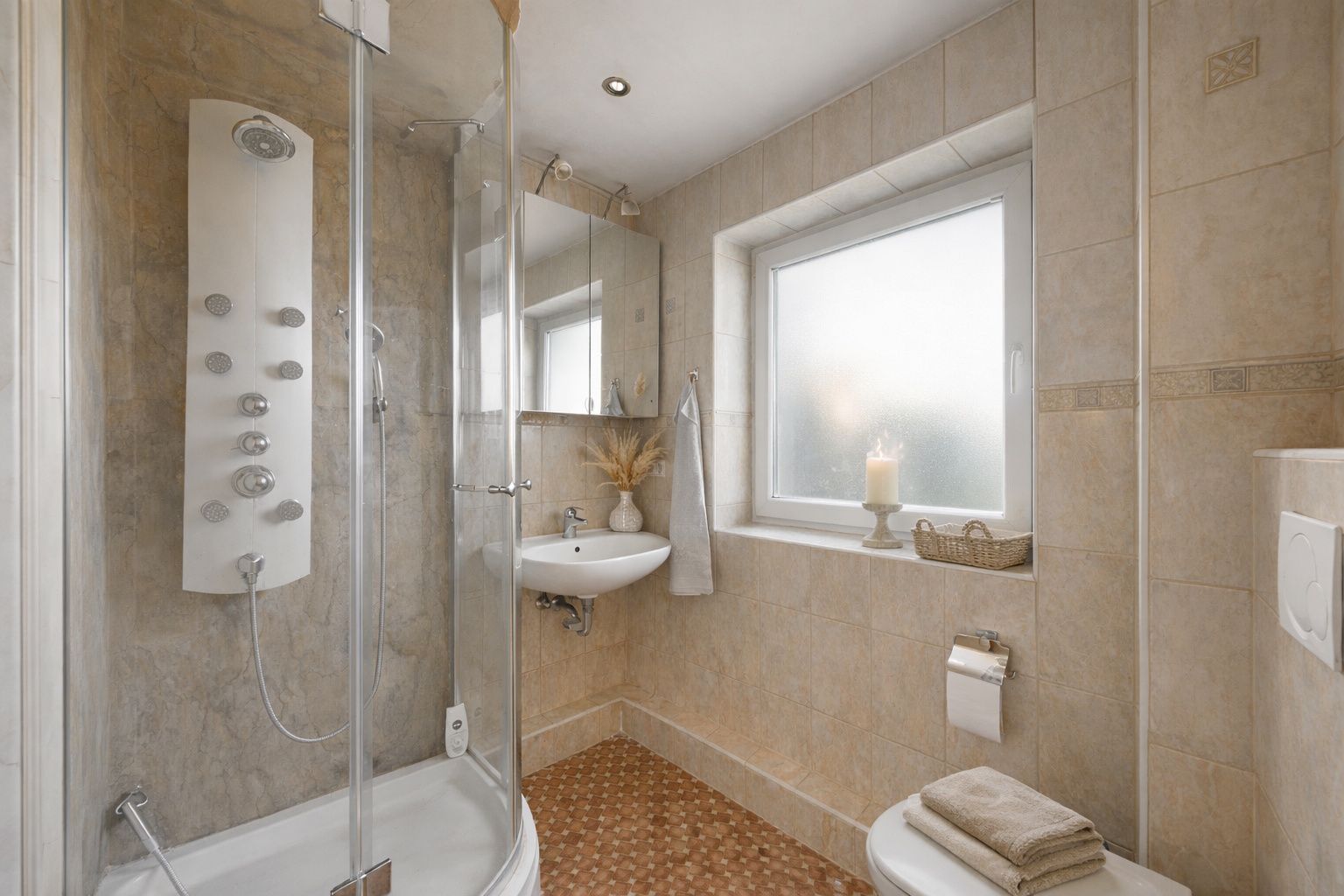 Modernes Badezimmer mit Dusche, Waschbecken, WC und Fenster mit Kerze auf der Fensterbank.