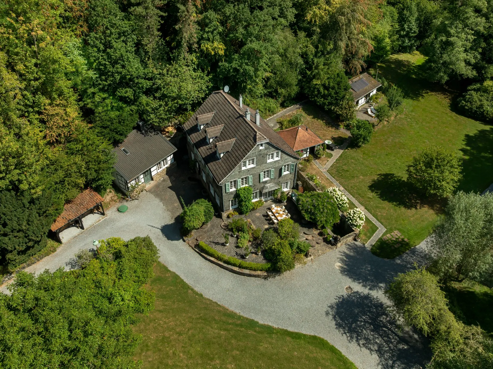 Luftaufnahme eines Wohnhauses mit Garten und umliegenden Bäumen.