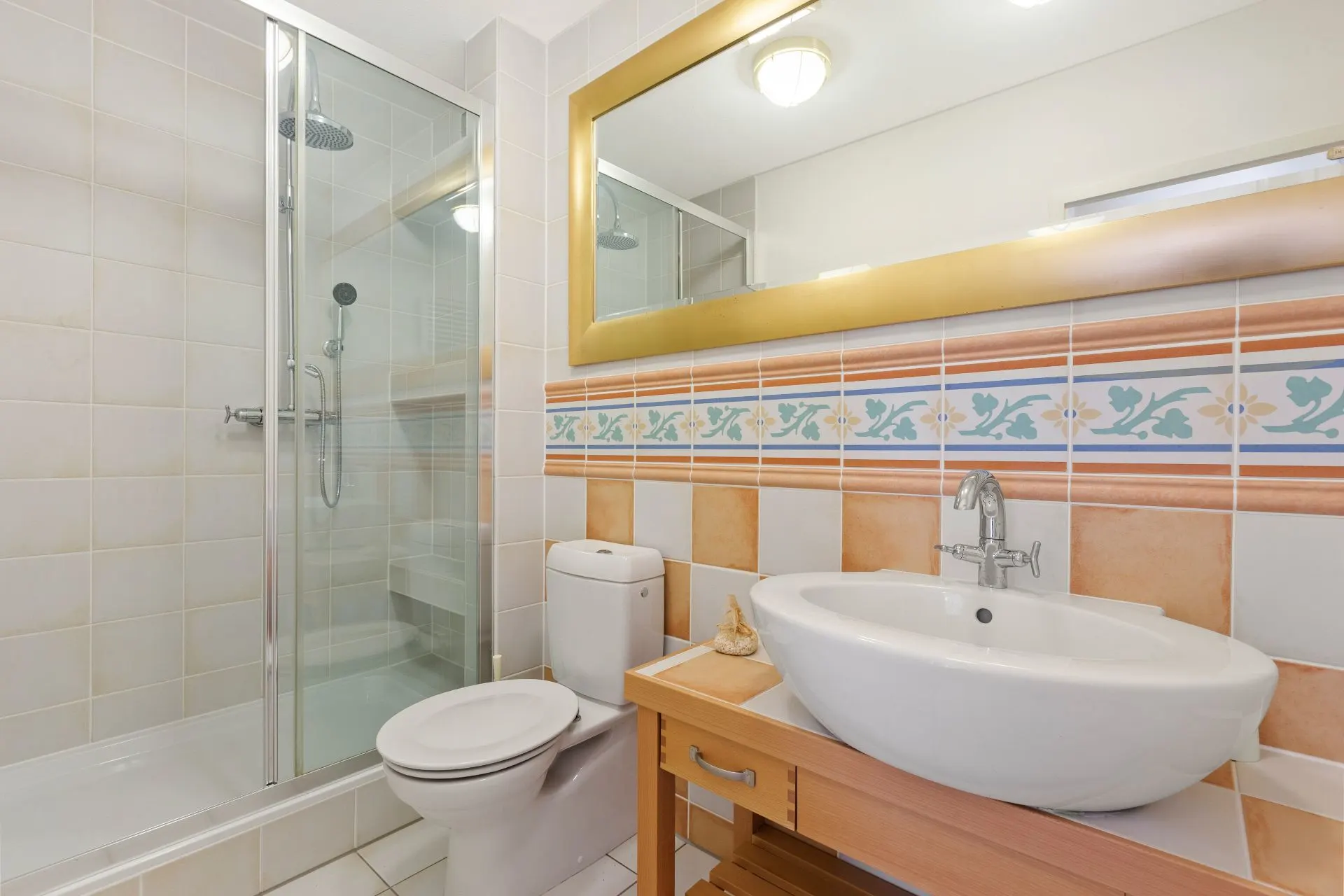 Helles Badezimmer mit großer Dusche, Toilette, Waschbecken und großem Spiegel.