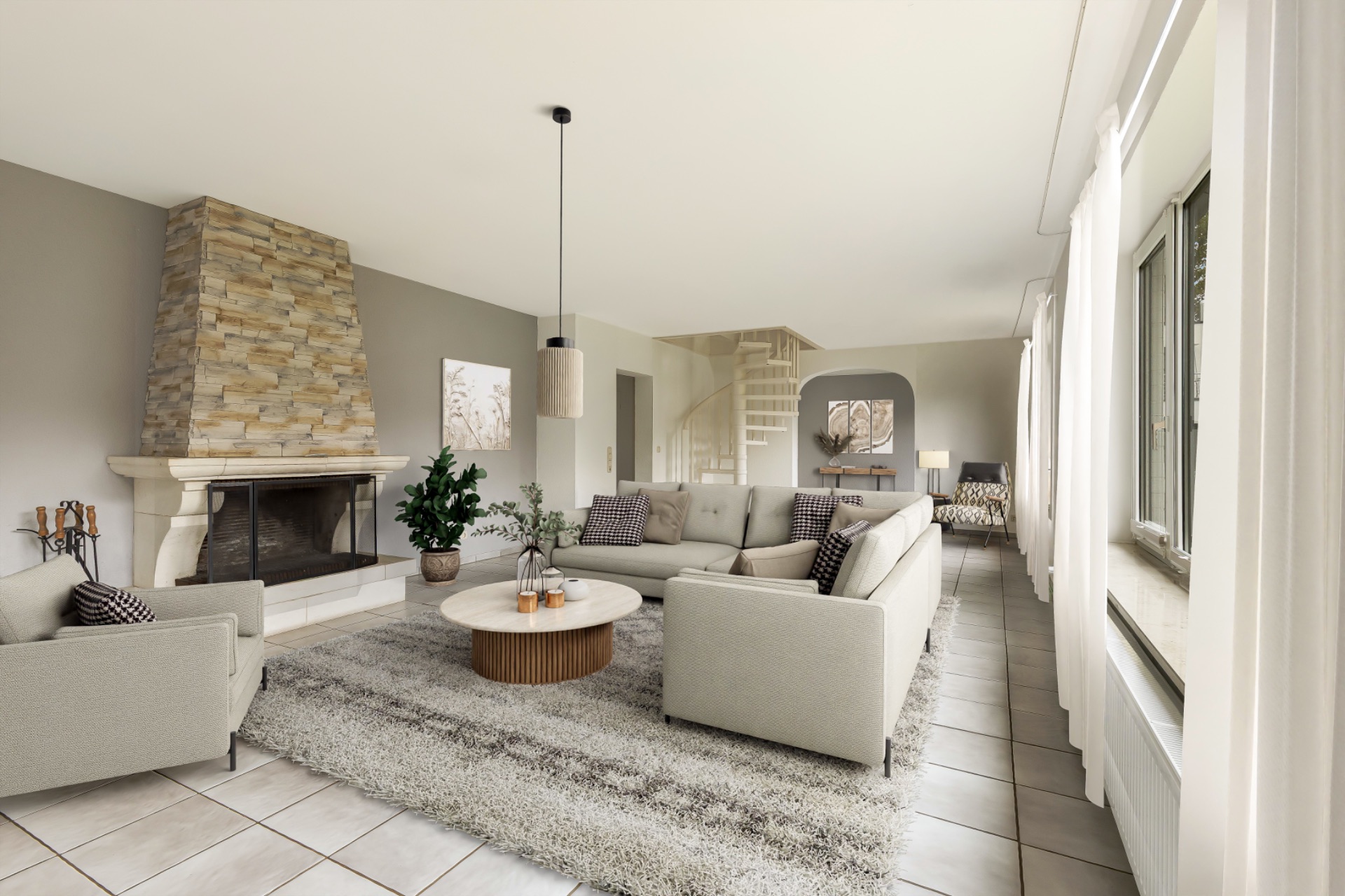 Helles Wohnzimmer mit Kamin, Sofa, Teppich, großem Fenster und runder Treppe im Hintergrund.