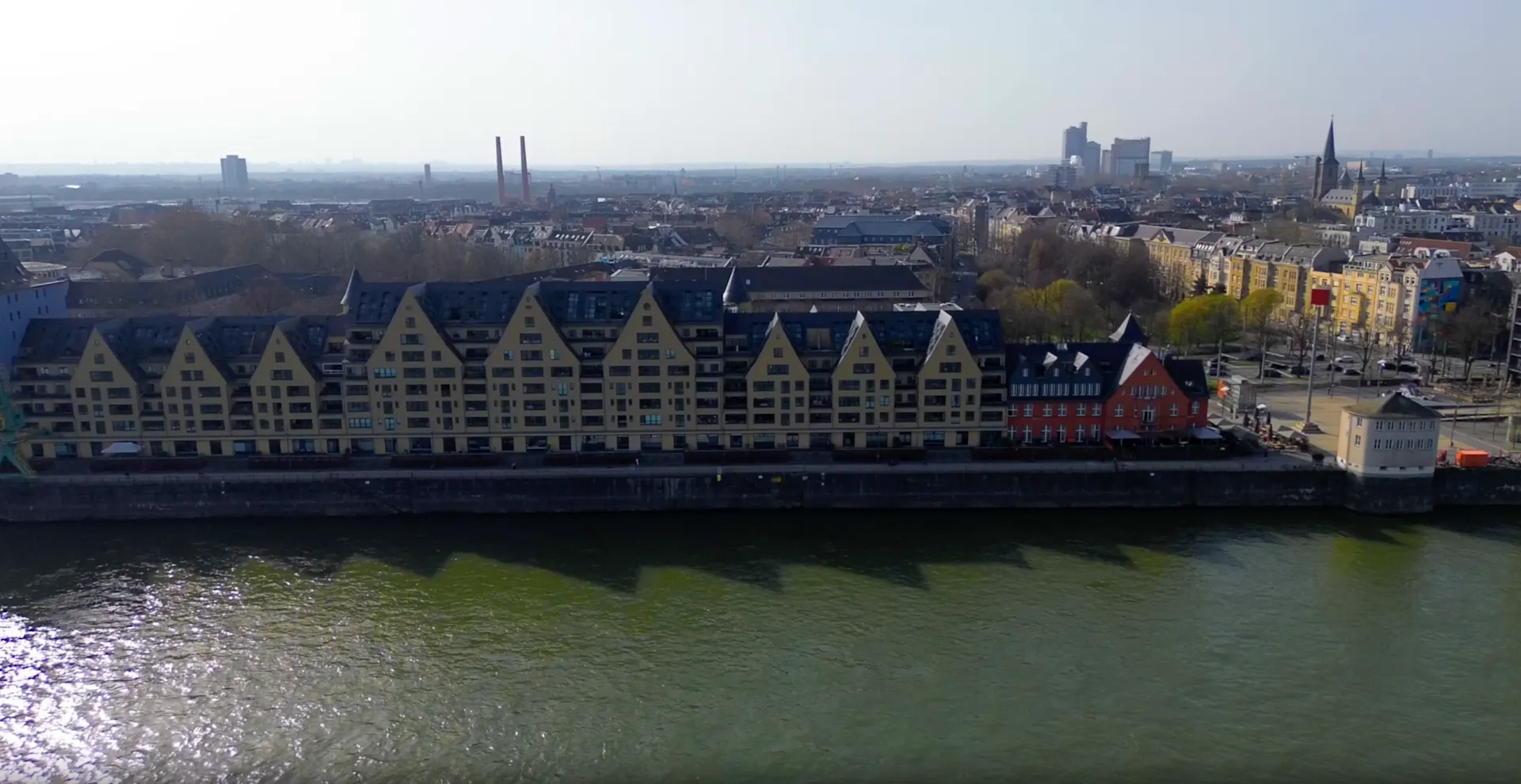 Helles Wohnzimmer mit Essbereich, Holzboden, großen Fenstern und Blick auf einen Fluss.