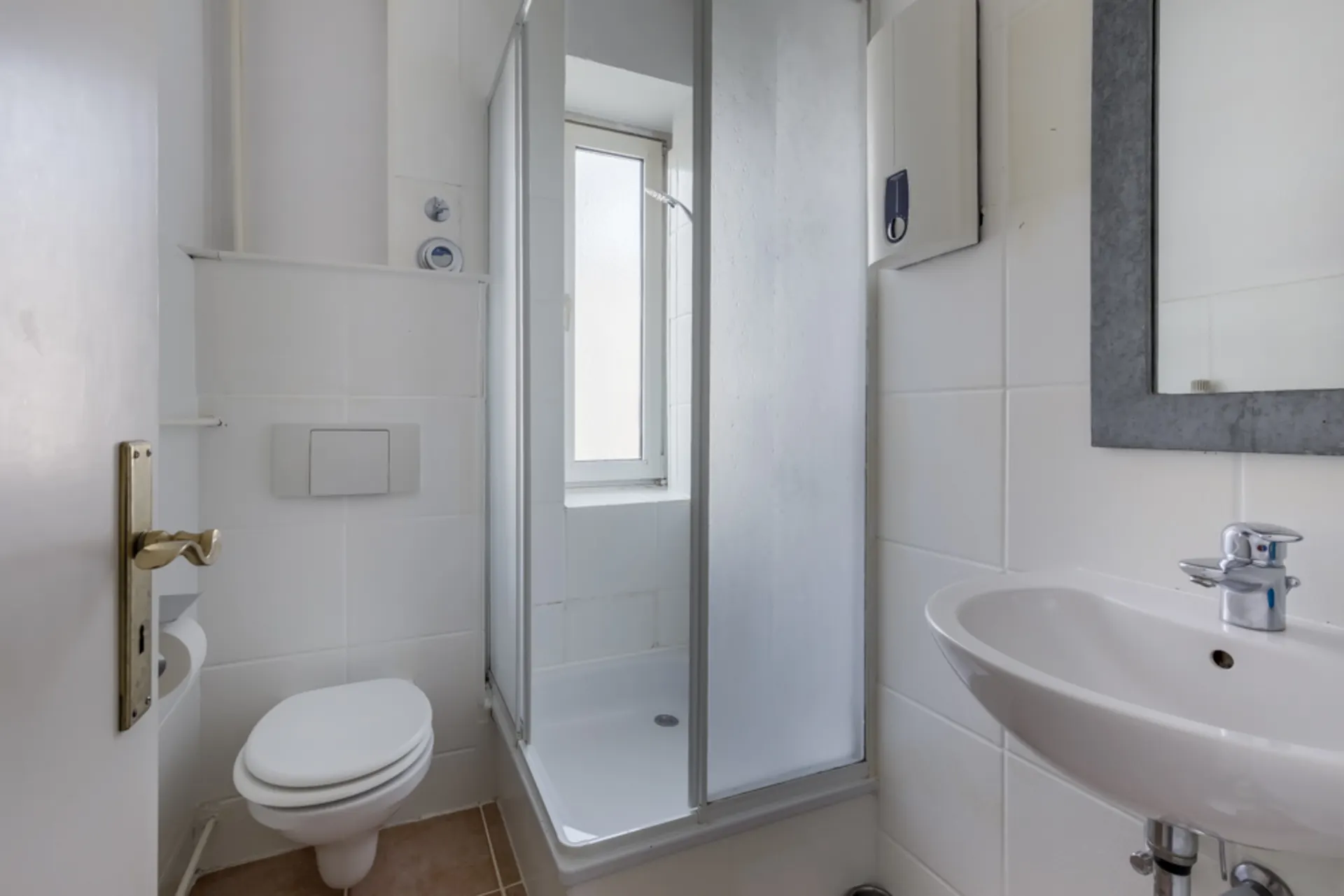 Kleines Badezimmer mit Dusche, Toilette, Waschbecken und Spiegel, helle Fliesen.