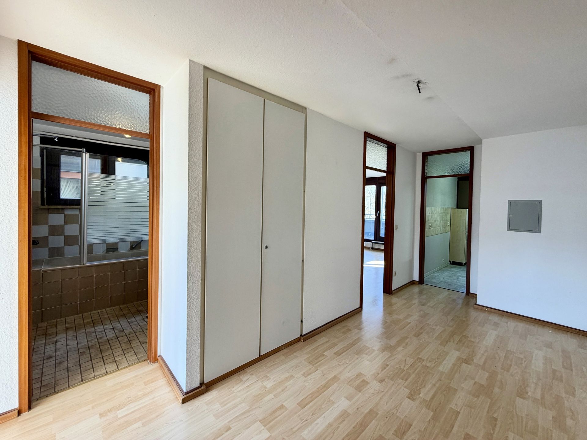 Flur mit Holzfußboden, Türen zu Bad und weiteren Räumen, großer Einbauschrank an der Wand.