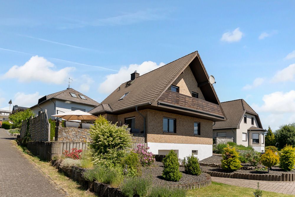 Einfamilienhaus mit Garten und Terrasse an einer ruhigen Wohnstraße.