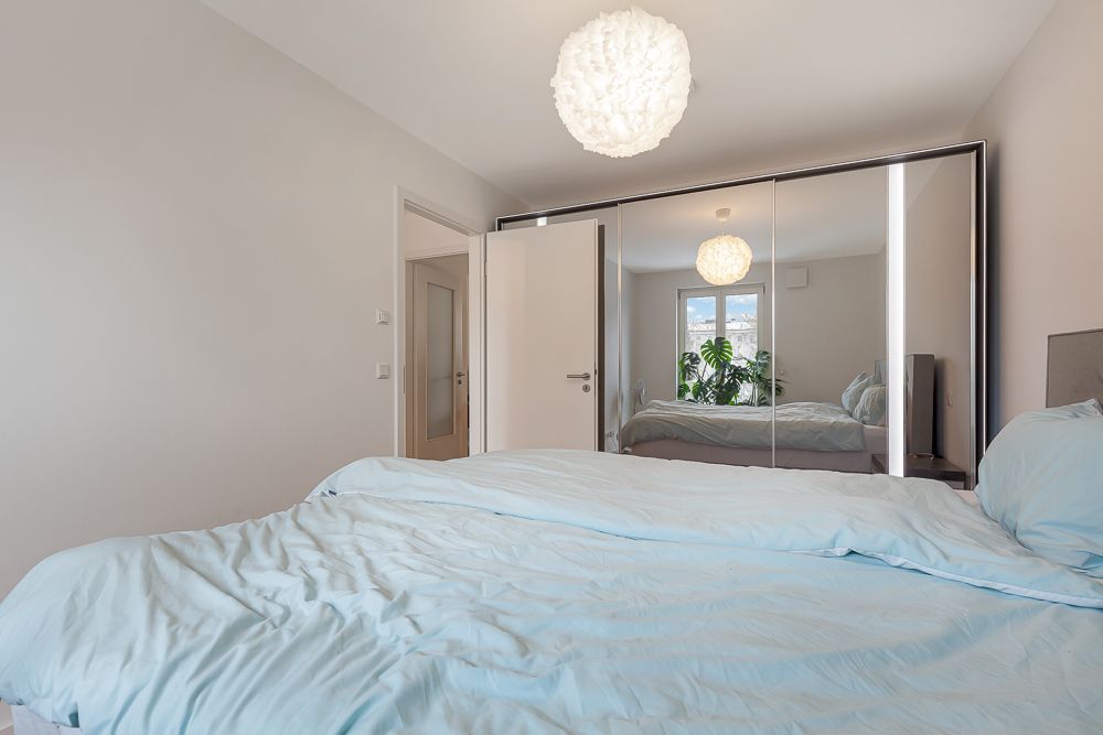 Schlafzimmer mit Doppelbett, Spiegel-Kleiderschrank und Fenster mit Ausblick.