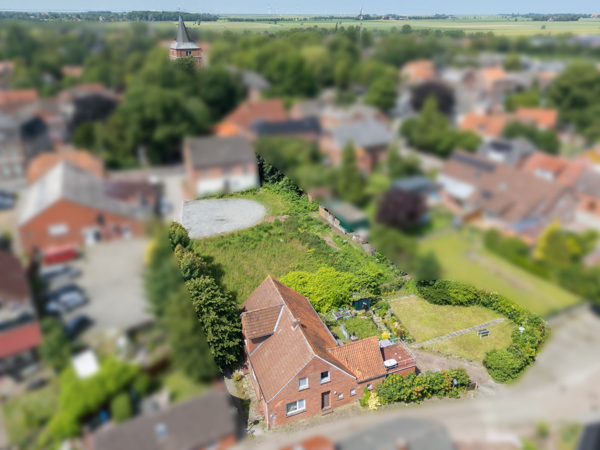 Luftaufnahme eines Hauses mit rotem Dach, großem Garten und umliegenden Wohnhäusern.