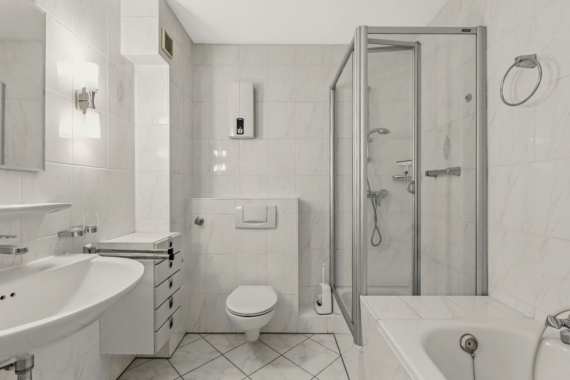 Helles Badezimmer mit Dusche, Badewanne, WC und Waschbecken.