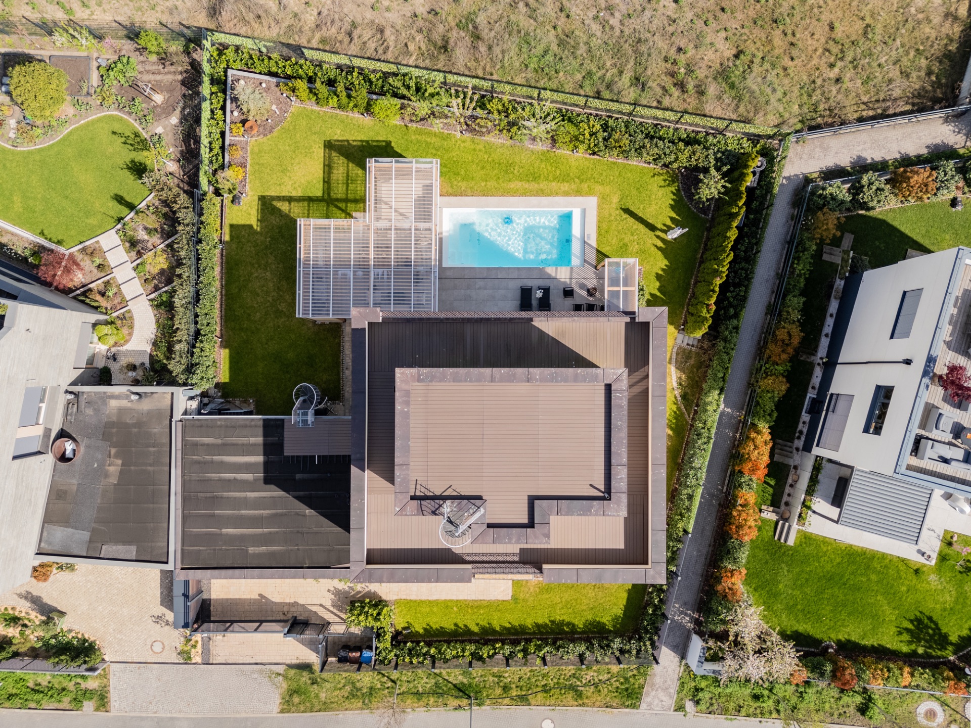 Luftbild eines modernen Wohnhauses mit Garten und Pool im Hinterhof.