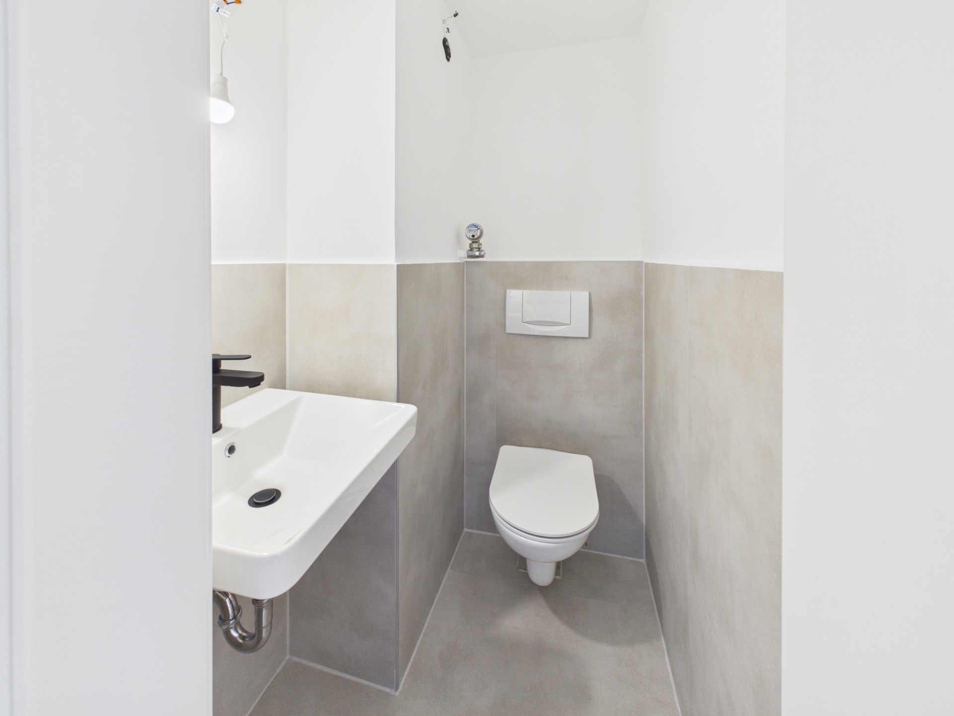 Kleines, modernes WC mit Hänge-Toilette und Wandwaschbecken.