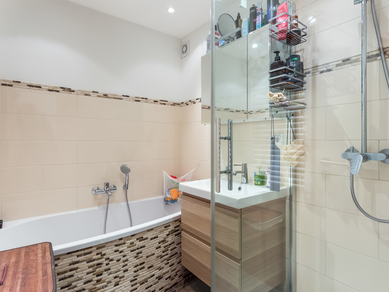 Modernes Badezimmer mit Badewanne, Waschbecken und einer verglasten Dusche.
