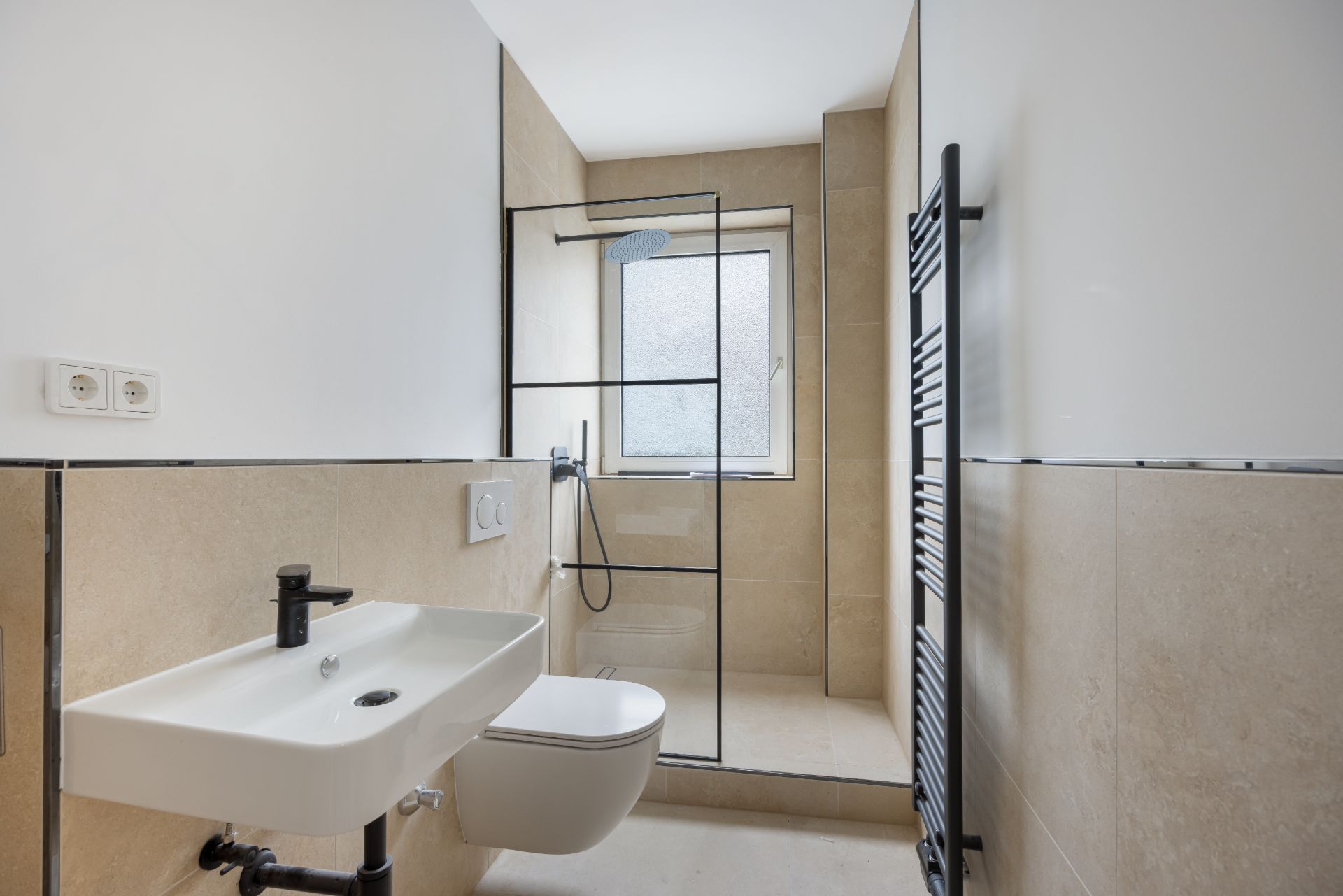 Modernes Badezimmer mit Waschbecken, Wand-WC, offener Dusche und Fenster.