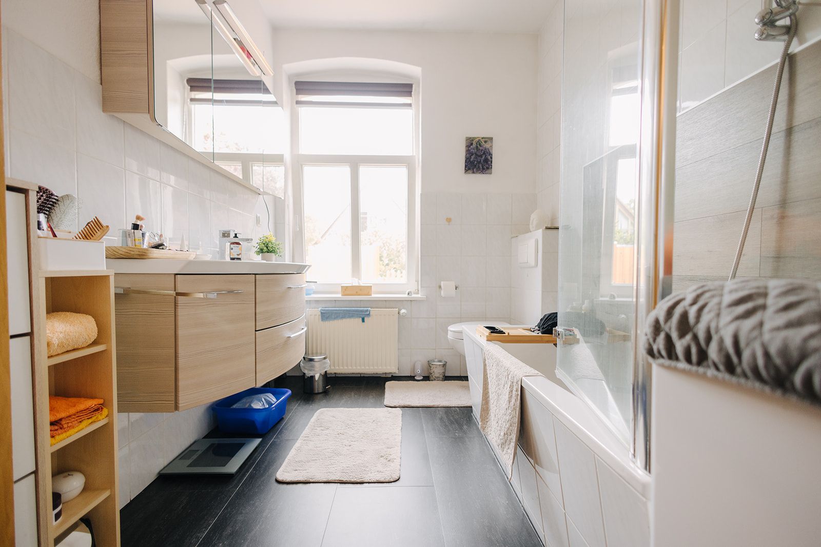 Modernes Badezimmer mit Badewanne, Waschbecken, Spiegel und großem Fenster.