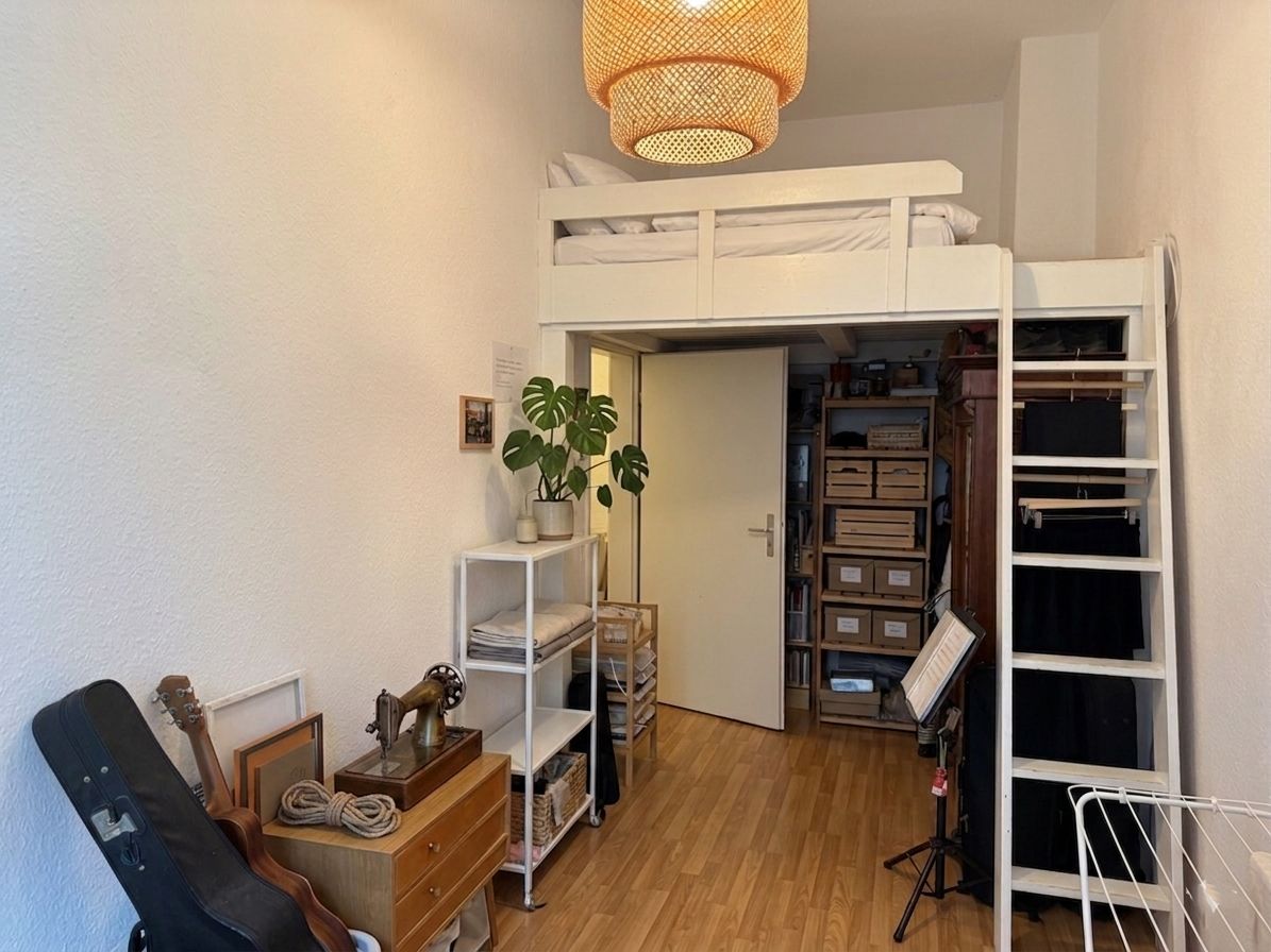 Kleines Zimmer mit Hochbett, Regal, offener Tür und verschiedenen Aufbewahrungsboxen und Möbeln.